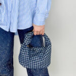 Borsa modello a sella da donna in denim con nodo sul manico.
