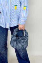 Borsa modello a sella da donna in denim con nodo sul manico.