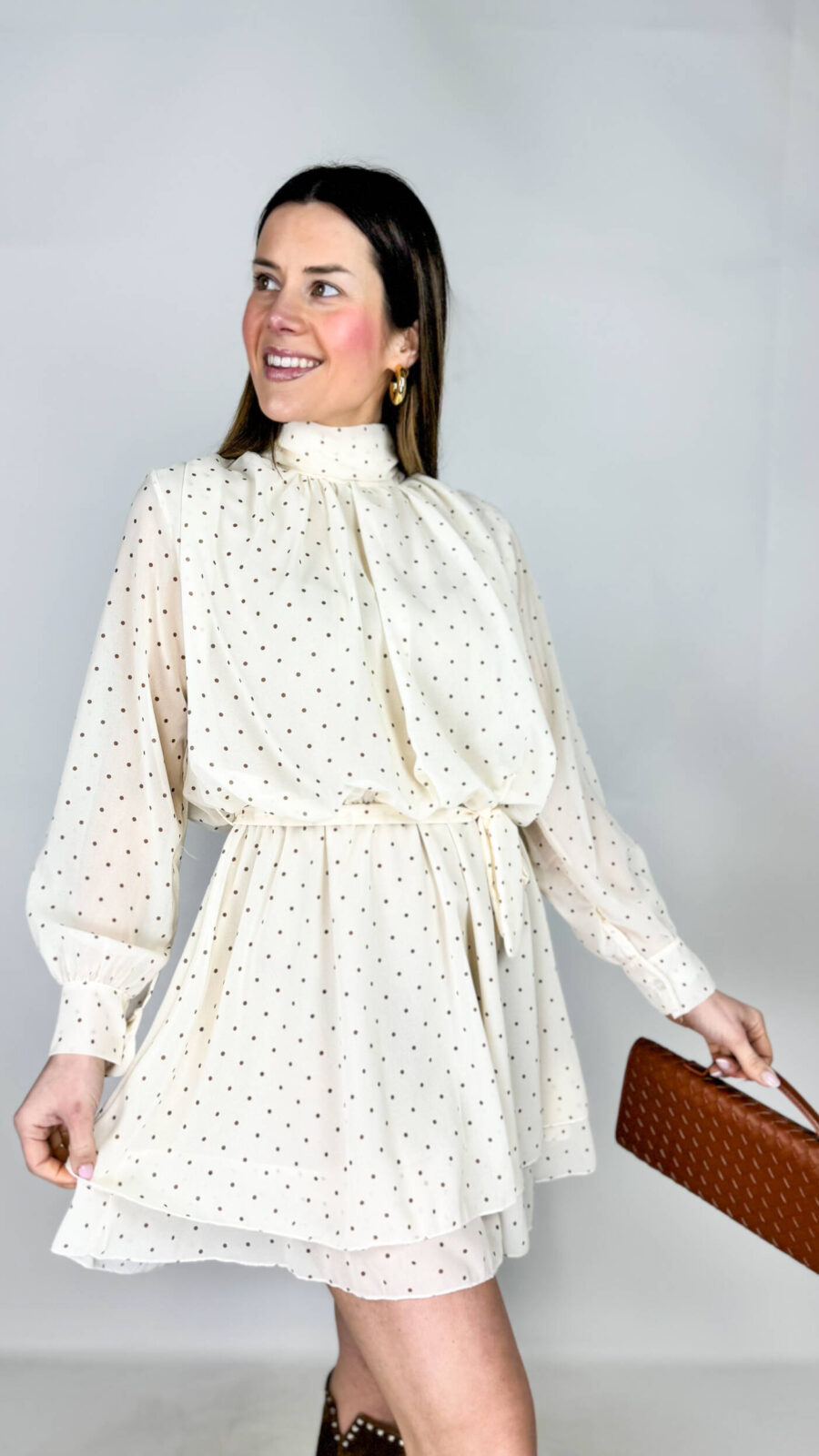 Vestito in fantasia a pois, dal fascino giocoso e femminile. Il collo alto dona un tocco sofisticato, mentre la vita elasticizzata valorizza la silhouette con comfort e naturalezza. La gonna morbida scivola delicatamente,