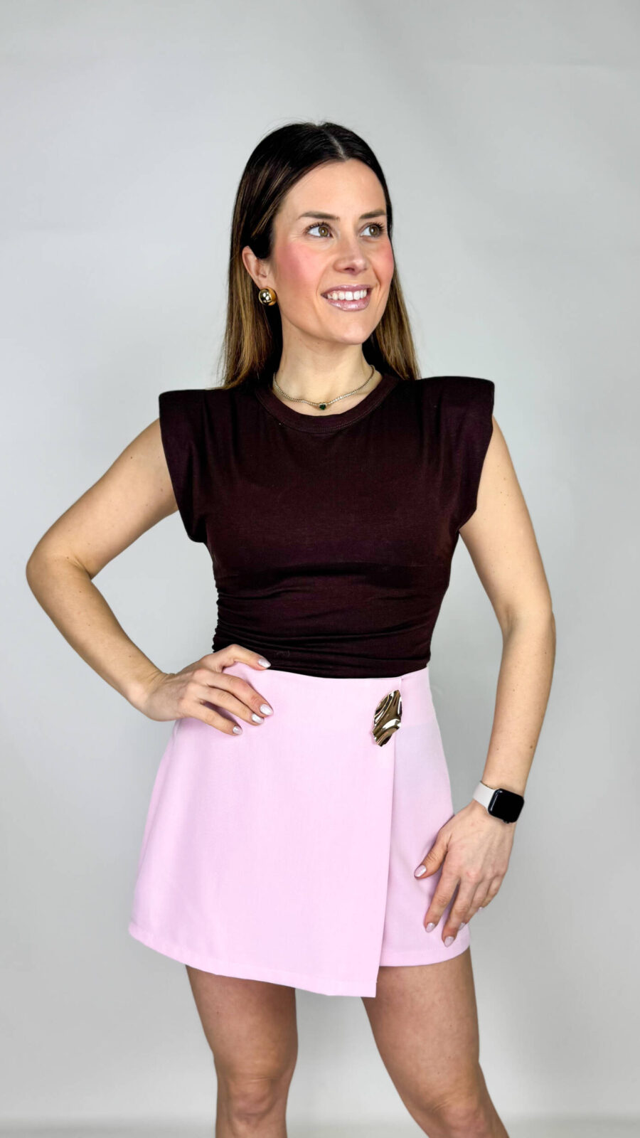 Una canotta marrone dal carattere deciso e raffinato, pensata per valorizzare la silhouette con dettagli di tendenza. Le spalline imbottite strutturano la linea delle spalle, donando equilibrio e un tocco contemporaneo dal fascino sofisticato.