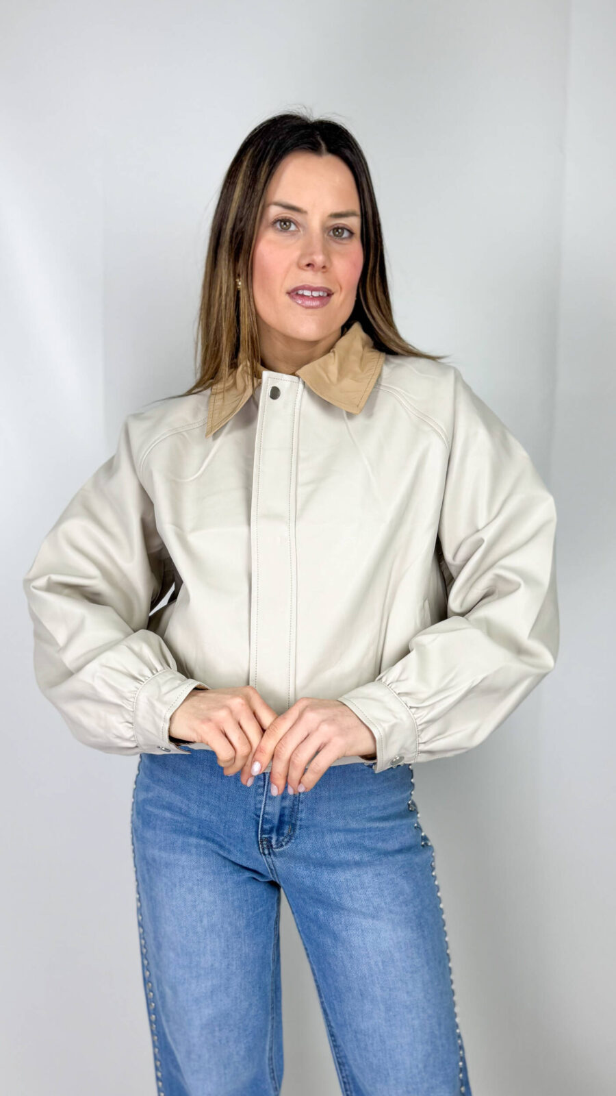 Una giacca bomber mezza stagione in ecopelle beige con colletto color cammello è il perfetto equilibrio tra eleganza e stile casual contemporaneo.