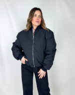 Giacca bomber nera imbottita con profili a costine Un classico rivisitato per il massimo comfort e stile: questo bomber nero unisce design urbano e funzionalità. La imbottitura interna a piumino garantisce calore e protezione nelle giornate più fredde, mentre il tessuto esterno resistente assicura durata e praticità.