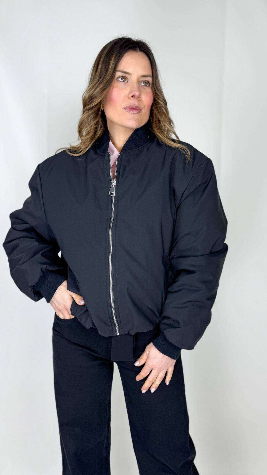 Giacca bomber nera imbottita con profili a costine Un classico rivisitato per il massimo comfort e stile: questo bomber nero unisce design urbano e funzionalità. La imbottitura interna a piumino garantisce calore e protezione nelle giornate più fredde, mentre il tessuto esterno resistente assicura durata e praticità.