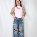 Jeans dal carattere deciso e contemporaneo, caratterizzati da gamba larga che dona comfort e uno stile moderno. Il design è reso ancora più originale dalla chiusura incrociata in vita, dettaglio di tendenza che valorizza la silhouette e rende il capo unico. Gli strappi sul davanti aggiungono un tocco grintoso e urban, perfetto per creare outfit casual ma di forte personalità. Ideali da abbinare a t-shirt, top o giacche per un look moderno e di grande impatto.