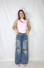 Jeans dal carattere deciso e contemporaneo, caratterizzati da gamba larga che dona comfort e uno stile moderno. Il design è reso ancora più originale dalla chiusura incrociata in vita, dettaglio di tendenza che valorizza la silhouette e rende il capo unico. Gli strappi sul davanti aggiungono un tocco grintoso e urban, perfetto per creare outfit casual ma di forte personalità. Ideali da abbinare a t-shirt, top o giacche per un look moderno e di grande impatto.