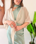 Coprispalle elegante in tessuto leggero e velato, perfetto per completare abiti da cerimonia con un tocco di raffinatezza. Il modello si allaccia delicatamente sul petto, creando un effetto morbido e femminile. Le maniche corte ampie donano movimento e leggerezza, rendendolo ideale da indossare sopra abiti eleganti durante cerimonie ed eventi speciali.