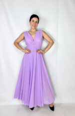 Abito romantico e femminile con scollo a V sia davanti che sul retro, che valorizza delicatamente il décolleté e la schiena. La vita con elastico definisce la silhouette garantendo comfort e vestibilità. La gonna è arricchita da una morbida sottogonna in cotone con strati di tulle color lilla che donano volume, leggerezza e un elegante effetto vaporoso. Perfetto per cerimonie, feste ed eventi speciali.