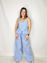 Coordinato Mia fresco e sofisticato, composto da pantaloni a palazzo e top crop coordinato. I pantaloni, ampi e fluidi, scendono morbidi lungo la gamba