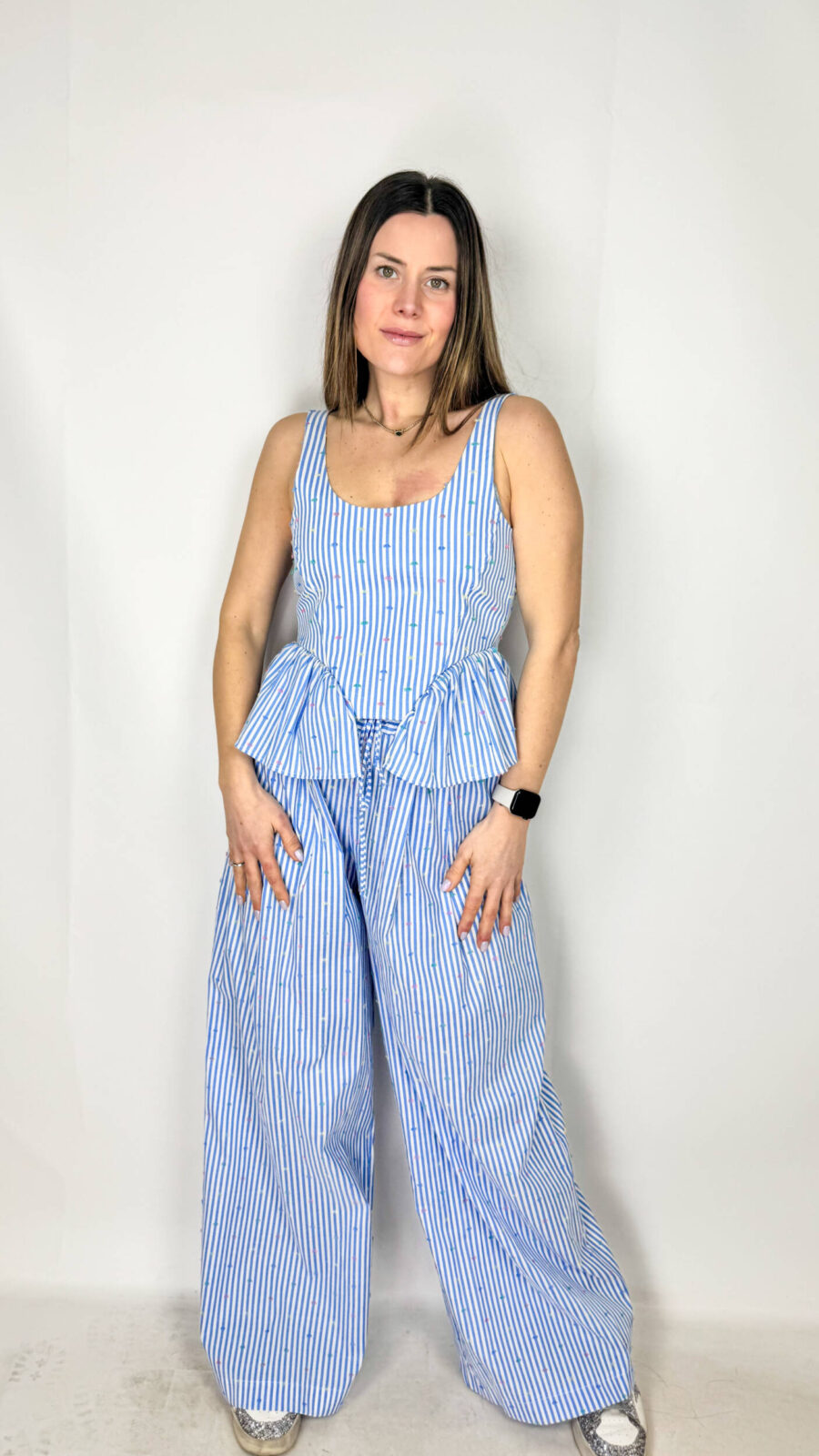 Coordinato Mia fresco e sofisticato, composto da pantaloni a palazzo e top crop coordinato. I pantaloni, ampi e fluidi, scendono morbidi lungo la gamba