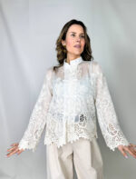 Camicia Japan elegante realizzata con un tessuto semi-trasparente, impreziosita dal ricamo floreale. Il collo alto leggermente strutturato aggiunge un tocco sofisticato mentre le maniche ampie terminano con polsini lavorati in pizzo.