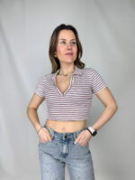 Dona carattere ai tuoi look con questo top crop a righe, perfetto per unire eleganza e freschezza in un capo versatile. Il design corto valorizza la silhouette, mentre lo scollo a V slancia il décolleté aggiungendo un tocco femminile. Il collo a camicia, invece, richiama uno stile più strutturato e sofisticato, creando un equilibrio perfetto tra casual e chic