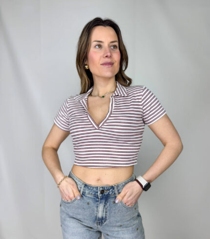 Dona carattere ai tuoi look con questo top crop a righe, perfetto per unire eleganza e freschezza in un capo versatile. Il design corto valorizza la silhouette, mentre lo scollo a V slancia il décolleté aggiungendo un tocco femminile. Il collo a camicia, invece, richiama uno stile più strutturato e sofisticato, creando un equilibrio perfetto tra casual e chic