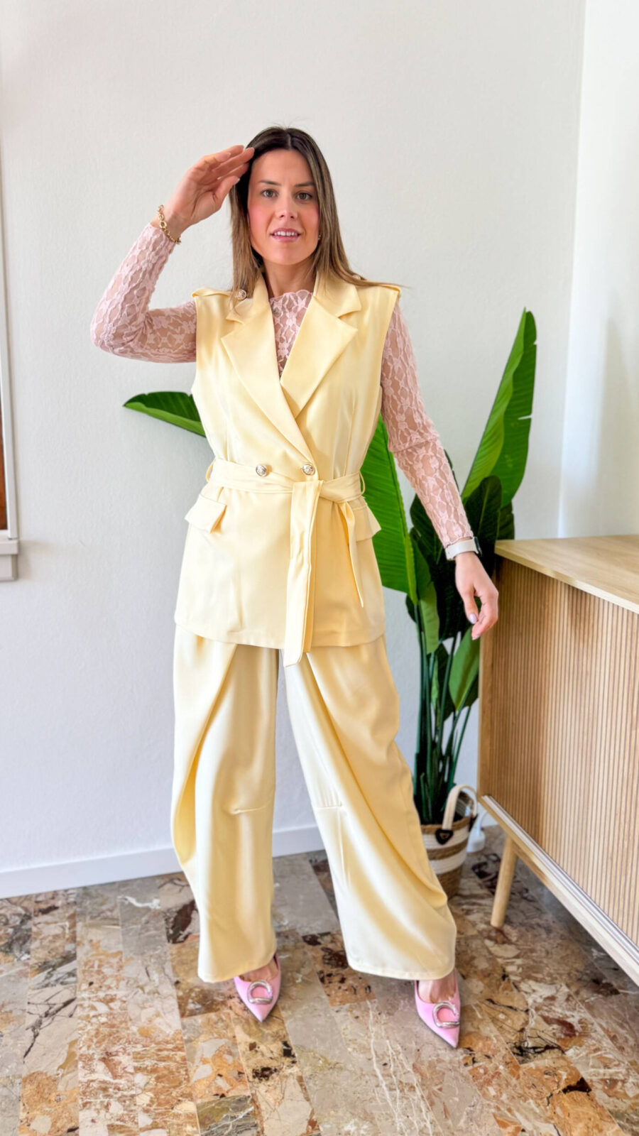 Coordinato dal carattere deciso e contemporaneo, pensato per chi ama distinguersi con eleganza. Il gilet doppiopetto è il protagonista assoluto: strutturato, con una linea sartoriale impeccabile, è impreziosito da bottoni dorati che decorano sia la chiusura frontale sia le spalline, aggiungendo un tocco sofisticato e distintivo. La cintura regolabile in vita valorizza la silhouette, permettendo una vestibilità personalizzata e femminile. Il pantalone a gamba larga completa il look con un’attitudine moderna e fluida. Caratterizzato da una doppia chiusura frontale, riprende il design dei modelli più iconici e di tendenza del 2026, offrendo una struttura pulita e un fit impeccabile.