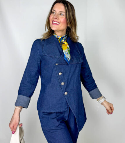 Coordinato in leggero denim primaverile, fresco e contemporaneo, ideale per la mezza stagione. Il pantalone, con elastico in vita, presenta una linea morbida a ovetto che avvolge la silhouette con comfort e stile. La giacca, dal design originale, si chiude frontalmente in modo trasversale ed è impreziosita da bottoni dorati che aggiungono un tocco luminoso e sofisticato. Un completo moderno e ricercato, perfetto per look casual-chic dal carattere distintivo.