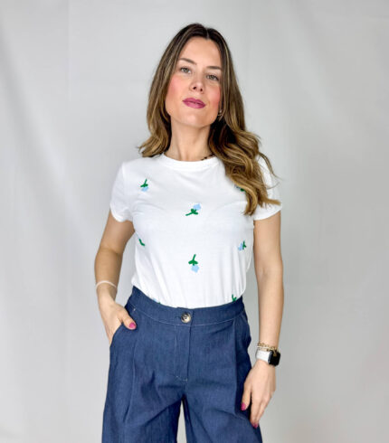 T-shirt in morbido cotone, leggera e confortevole, perfetta per la stagione primaverile ed estiva. Il design è impreziosito da delicati fiorellini applicati sul davanti, nelle tonalità fresche dell’azzurro e del verde, che donano un tocco romantico e naturale al capo