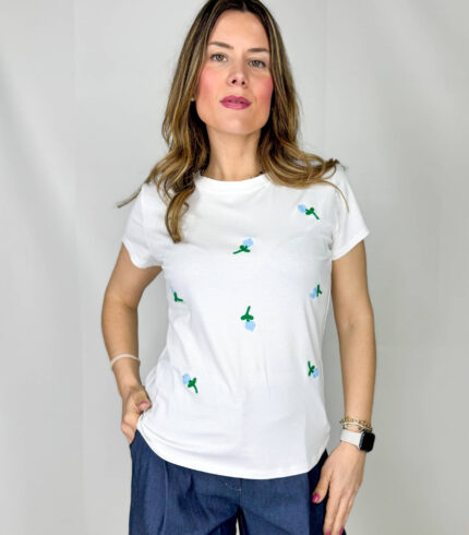 T-shirt in morbido cotone, leggera e confortevole, perfetta per la stagione primaverile ed estiva. Il design è impreziosito da delicati fiorellini applicati sul davanti, nelle tonalità fresche dell’azzurro e del verde, che donano un tocco romantico e naturale al capo