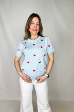 Pullover girocollo in 100% viscosa, leggero e morbido al tatto, ideale per un comfort quotidiano con un tocco femminile. Il modello a manica corta è impreziosito da delicati cuori rossi ricamati, che aggiungono un dettaglio romantico e vivace al capo. La lavorazione a costine sul fondo garantisce una vestibilità stabile e leggermente aderente