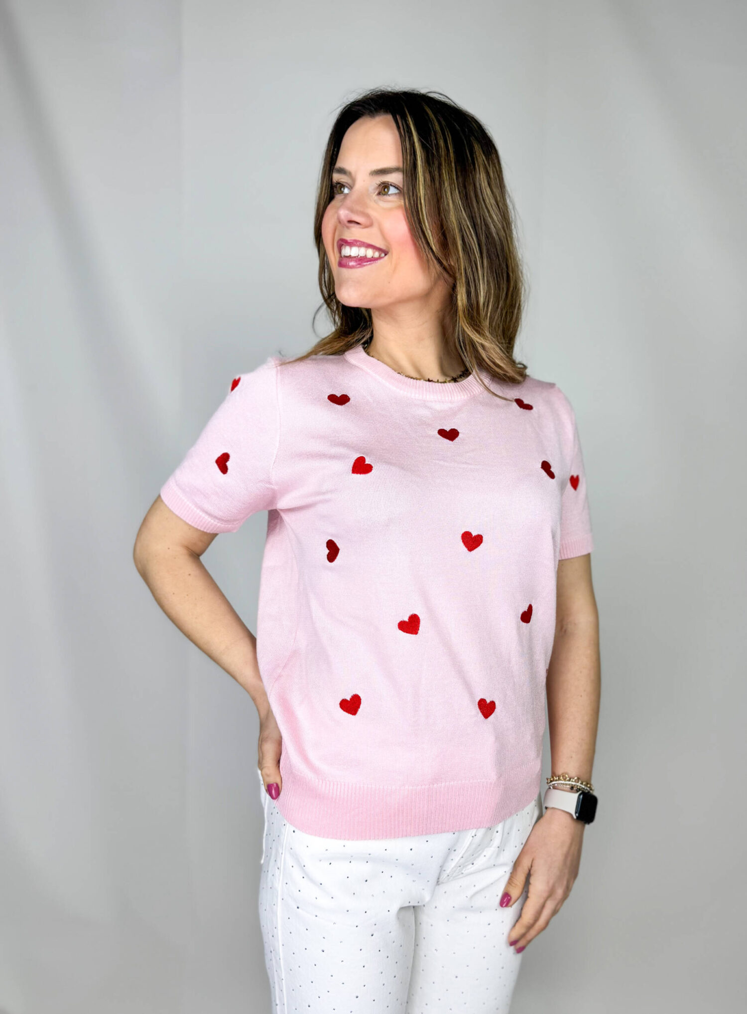 Pullover girocollo in 100% viscosa, leggero e morbido al tatto, ideale per un comfort quotidiano con un tocco femminile. Il modello a manica corta è impreziosito da delicati cuori rossi ricamati, che aggiungono un dettaglio romantico e vivace al capo. La lavorazione a costine sul fondo garantisce una vestibilità stabile e leggermente aderente