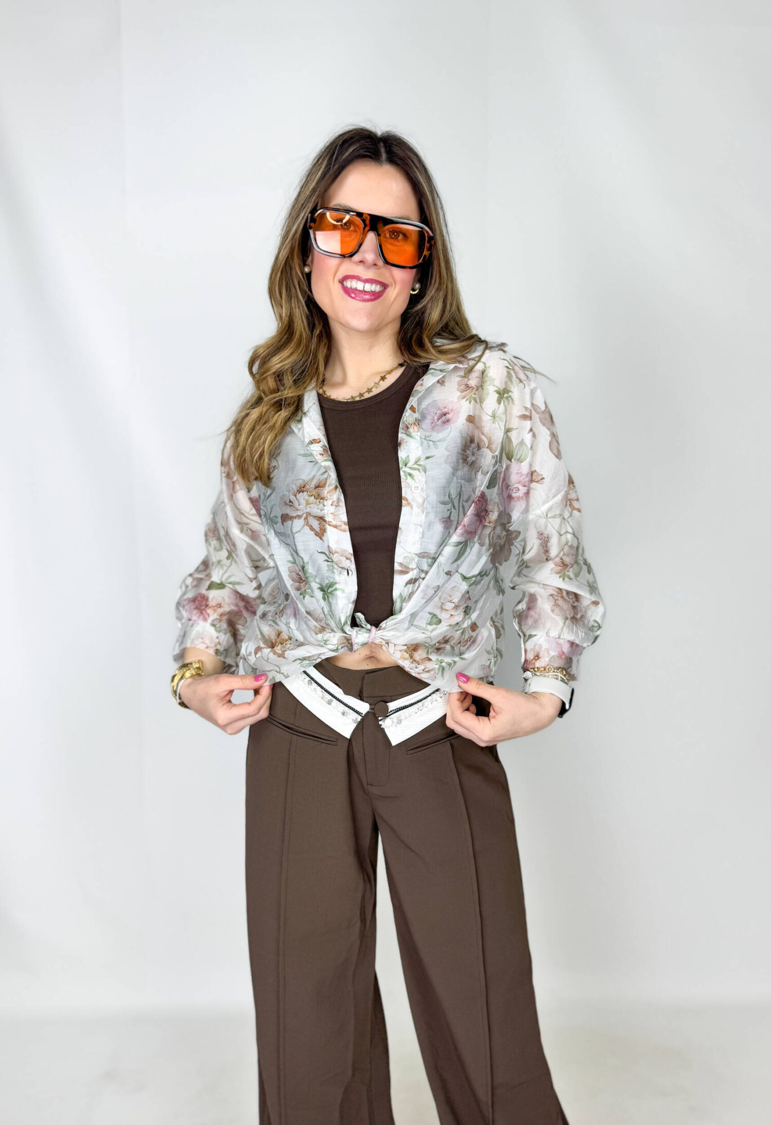 Camicia velata dalla delicata fantasia a fiorellini, leggera e femminile, perfetta per la stagione primaverile. Il tessuto impalpabile accarezza la silhouette, mentre le maniche 3/4 morbide donano movimento e comfort. Versatile e di tendenza, può essere indossata annodata in vita per un look fresco e dinamico, oppure lasciata morbida per un effetto più romantico e rilassato.