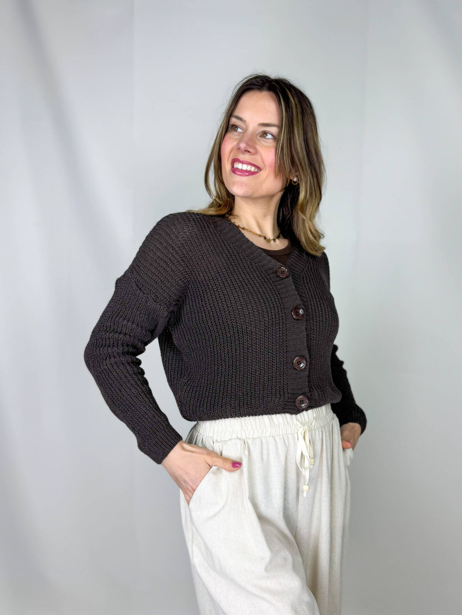 Golfino in cotone leggero dal taglio crop, perfetto per completare look freschi e femminili. Il design con scollo a V valorizza il décolleté, mentre i bottoni sul davanti aggiungono un dettaglio classico e versatile. Ideale da indossare sopra top e abiti o abbinato a pantaloni e gonne a vita alta, per uno stile semplice ma curato.