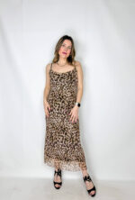 Abito lungo in fantasia leopardata, realizzato in tessuto elasticizzato che avvolge la silhouette esaltandone le forme con naturale eleganza. Il modello presenta uno scollo a barchetta raffinato, che valorizza le spalle, mentre la schiena leggermente scoperta aggiunge un tocco sensuale e sofisticato. La lunghezza alla caviglia slancia la figura, rendendo il capo ideale sia per il giorno che per la sera.