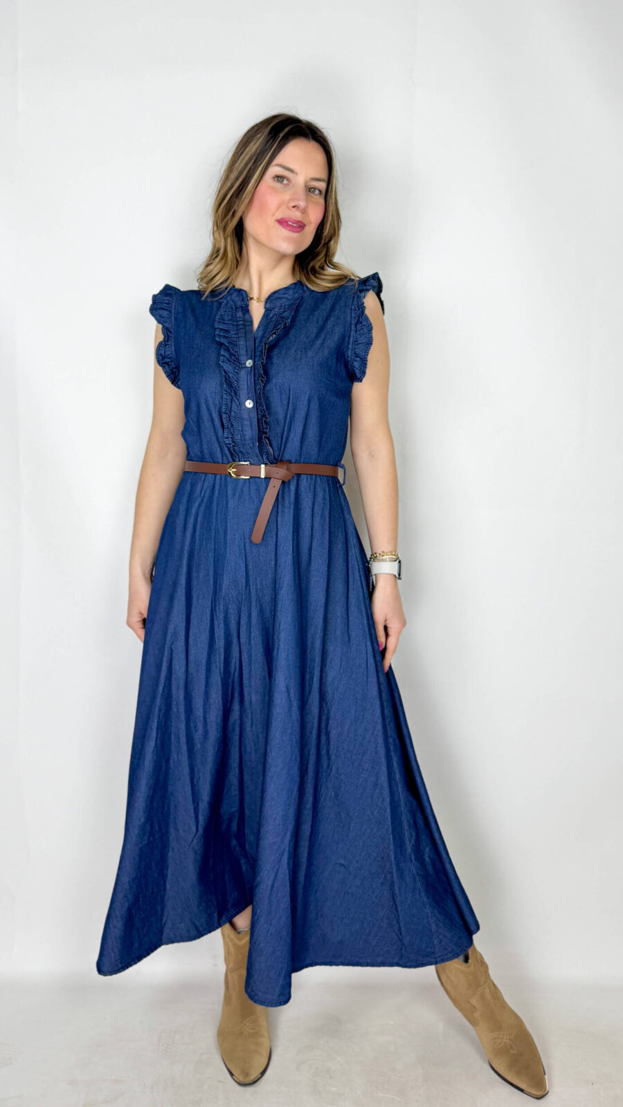 Abito in 100% denim di cotone, dal carattere fresco e contemporaneo, perfetto per uno stile casual-chic. Il top smanicato presenta un elegante collo alla coreana e un delicato rouge sul petto che aggiunge volume e femminilità al design. La gonna morbida scende fluida, donando movimento e comfort alla silhouette. In vita, la cintura regolabile marrone sottolinea il punto vita e completa il look