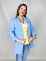 Top smanicato dal design femminile e romantico, caratterizzato da un elegante scollo a V che valorizza il décolleté. Sul davanti, una fila di deliziosi bottoncini a cuore aggiunge un dettaglio distintivo e raffinato. La linea aderente fino alla vita esalta la silhouette, per poi aprirsi con morbidezza in una leggera balza sul fondo che dona movimento