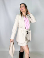 Il blazer Lara reinterpreta un classico del guardaroba con un equilibrio perfetto tra struttura e femminilità. Il design aperto sul davanti dona fluidità e leggerezza, mentre il collo con revers aggiunge un tocco sartoriale intramontabile. La cintura regolabile in vita permette di definire la silhouette, creando un fit personalizzabile che valorizza le forme. La lunghezza fino alla coscia rende il capo versatile e moderno, ideale sia per look formali che per abbinamenti più rilassati.