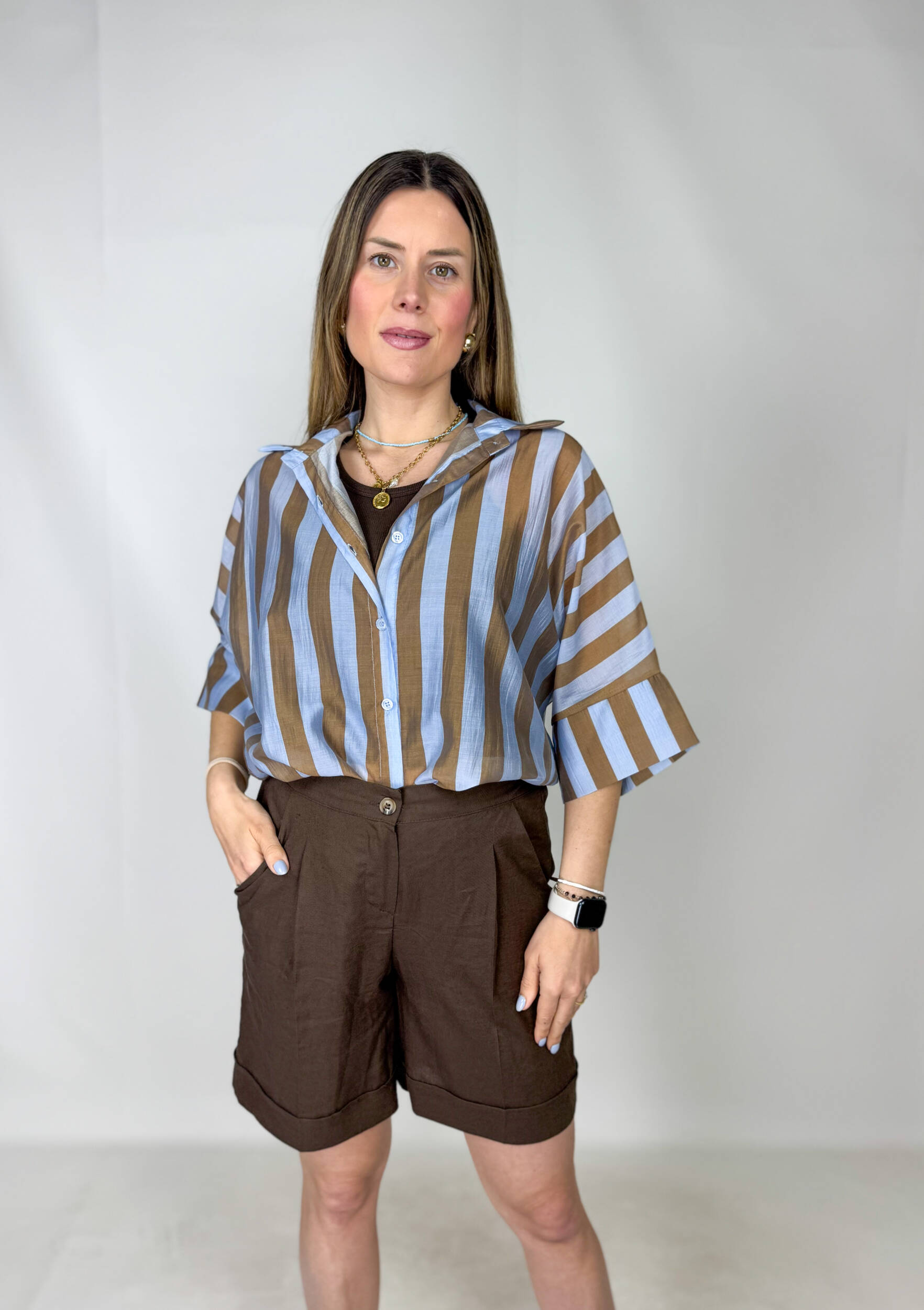 IMG_8616 Shorts marrone in lino dal design fresco ed elegante, perfetti per la stagione estiva. Il modello presenta pence in vita che valorizzano la silhouette e una pratica chiusura con zip e bottone per una vestibilità comoda e curata. L’elastico sul retro assicura comfort e adattabilità, mentre le tasche laterali aggiungono funzionalità al capo. Il risvoltino sul fondo completa il look con un tocco raffinato e versatile, ideale da abbinare a top, camicie o blazer leggeri.