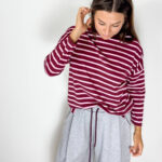 Maglia in cotone morbido dal gusto casual e senza tempo, caratterizzata da una classica fantasia a righe bordeaux e panna. Il modello presenta collo girocollo e maniche a 3/4, per una vestibilità pratica e versatile. Il design essenziale la rende un capo facile da indossare e da abbinare, perfetto per dare un tocco di carattere anche agli outfit più semplici. Ideale con denim, pantaloni sartoriali o bermuda per un look rilassato ma curato.
