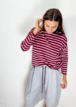 Maglia in cotone morbido dal gusto casual e senza tempo, caratterizzata da una classica fantasia a righe bordeaux e panna. Il modello presenta collo girocollo e maniche a 3/4, per una vestibilità pratica e versatile. Il design essenziale la rende un capo facile da indossare e da abbinare, perfetto per dare un tocco di carattere anche agli outfit più semplici. Ideale con denim, pantaloni sartoriali o bermuda per un look rilassato ma curato.