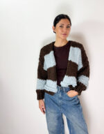Aggiungi un tocco di stile unico e avvolgente al tuo guardaroba invernale con questo splendido cardigan oversized lavorato a maglia grossa. Caratterizzato da un design a grandi righe orizzontali a contrasto, accosta l'eleganza profonda del marrone cioccolato alla freschezza e delicatezza dell'azzurro cielo. Realizzato con una ricca miscela ad alto contenuto di lana, è il capo perfetto da indossare aperto per un look effortless chic, moderno e alla moda.