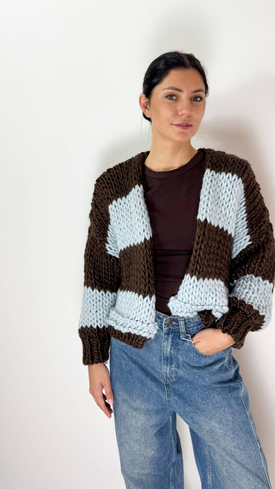 Aggiungi un tocco di stile unico e avvolgente al tuo guardaroba invernale con questo splendido cardigan oversized lavorato a maglia grossa. Caratterizzato da un design a grandi righe orizzontali a contrasto, accosta l'eleganza profonda del marrone cioccolato alla freschezza e delicatezza dell'azzurro cielo. Realizzato con una ricca miscela ad alto contenuto di lana, è il capo perfetto da indossare aperto per un look effortless chic, moderno e alla moda.