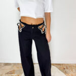 Jeans Maelle Black in denim lavaggio nero caratterizzato da dettagli cut-out con applicazioni di strass a stella. Fit morbido a palazzo e dettagli sfrangiati sul fondo. Taglia S: veste da una 36 a una 3