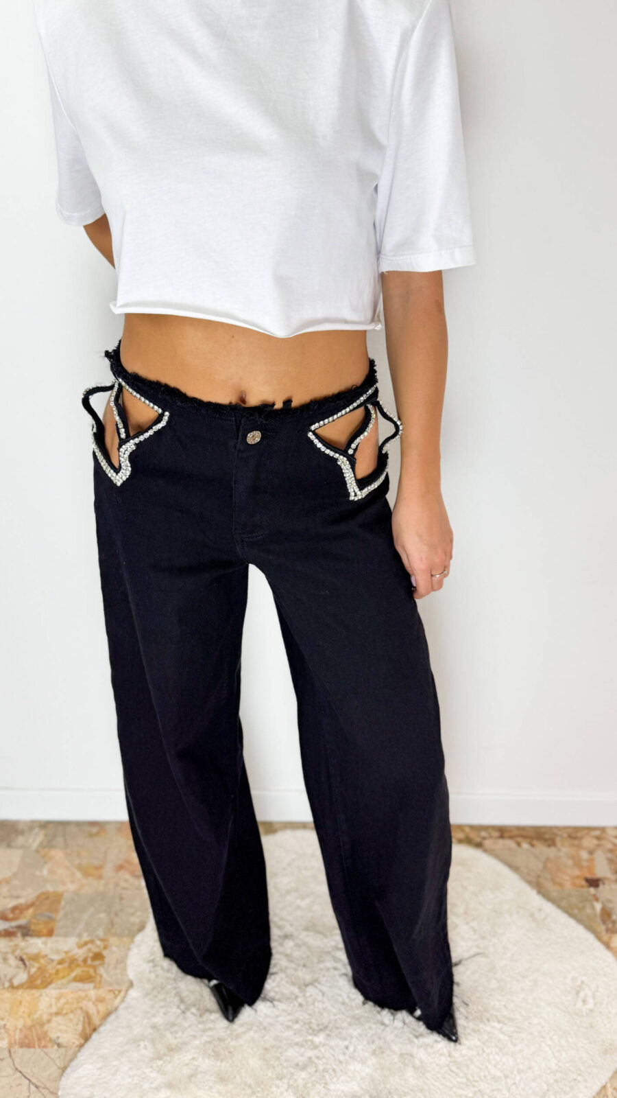 Jeans Maelle Black in denim lavaggio nero caratterizzato da dettagli cut-out con applicazioni di strass a stella. Fit morbido a palazzo e dettagli sfrangiati sul fondo. Taglia S: veste da una 36 a una 3