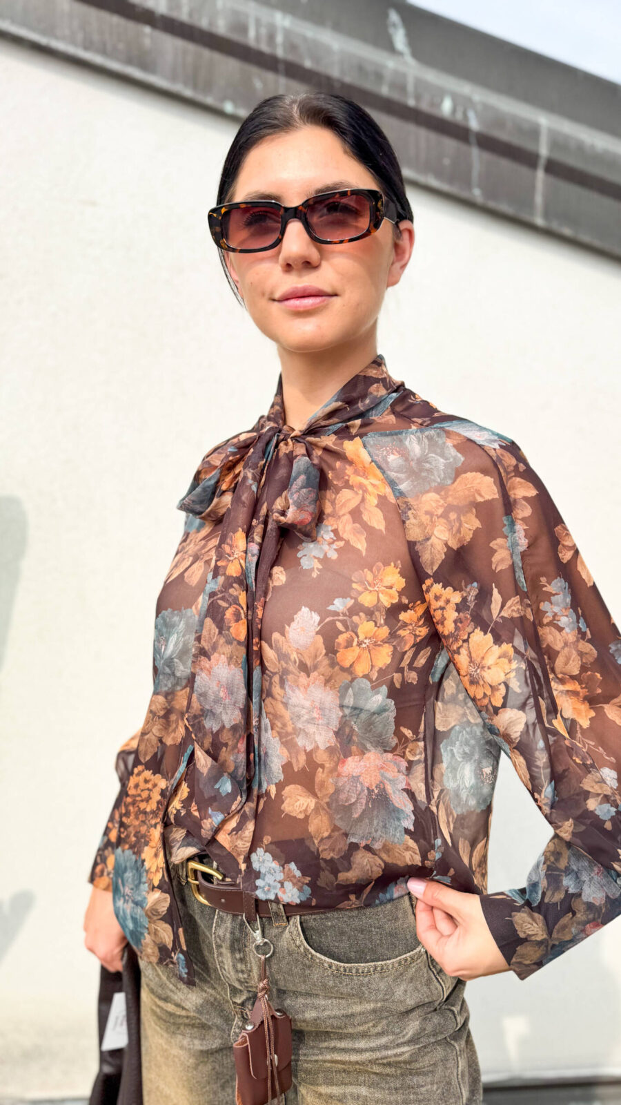 Camicia dalla linea morbida e comoda, caratterizzata da una vivace fantasia floreale nei toni del marrone, ruggine, blu e arancio. Il dettaglio protagonista è il fiocco sul collo, che dona un tocco femminile e originale al modello. La vestibilità fluida la rende facile da indossare e perfetta per creare look semplici ma con carattere. Da abbinare a jeans, pantaloni o gonne, è una camicia versatile ideale per dare un tocco di colore e personalità agli outfit di tutti i giorni.