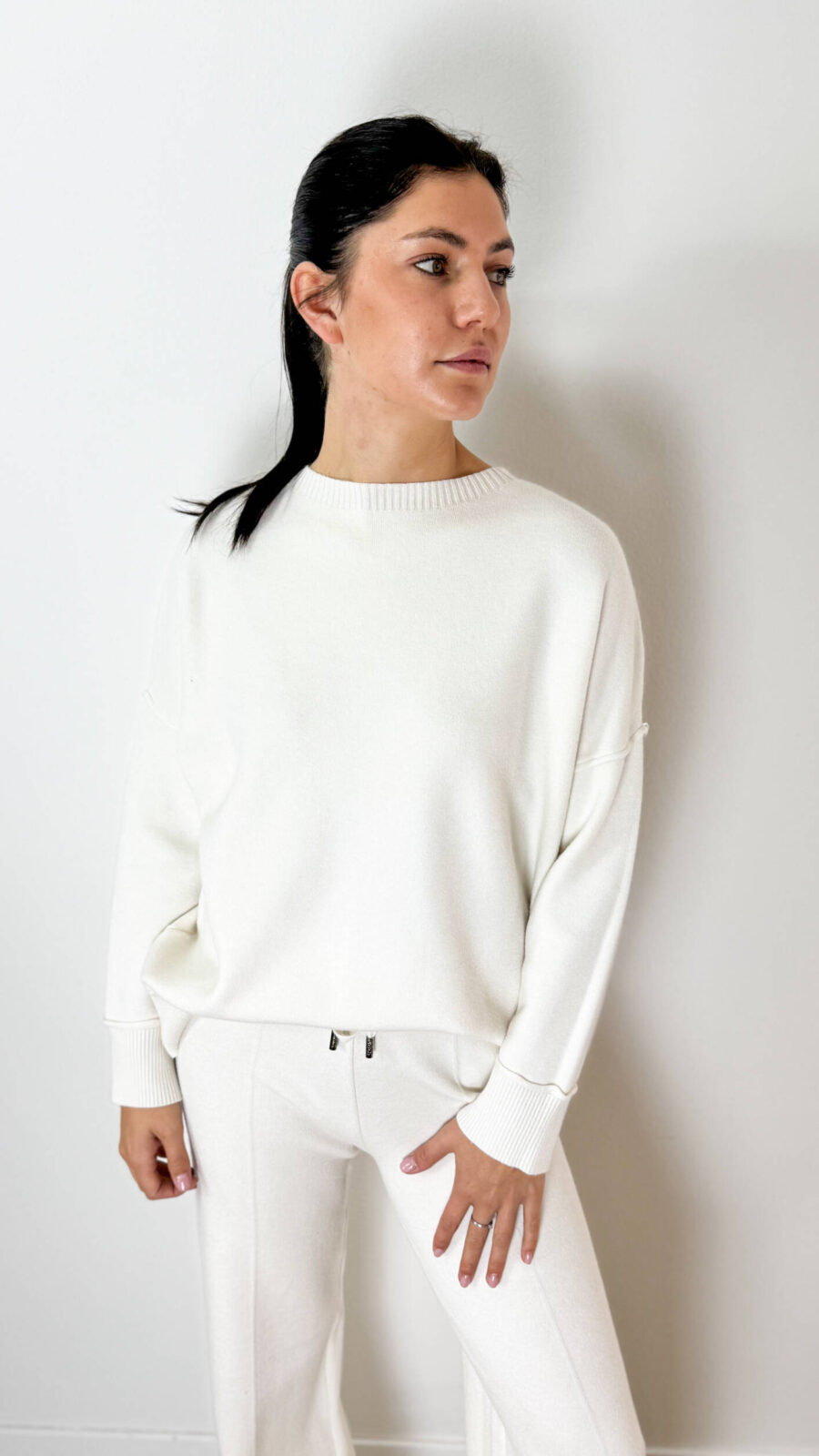 Vivi la stagione fredda nell'abbraccio del comfort assoluto con questo raffinato coordinato in calda maglia bianca. Realizzato in un tessuto morbidissimo ed altamente elasticizzato, questo set due pezzi unisce eleganza, praticità e una vestibilità avvolgente che si adatta delicatamente ad ogni silhouette. La sua eccezionale elasticità e morbidezza lo rendono un capo ideale e super confortevole anche durante il periodo della gravidanza. Il completo è composto da una maglia a girocollo con maniche lunghe dal taglio scivolato e da un pantalone morbido abbinato. Estremamente versatile, è perfetto sia indossato come total look per un outfit loungewear di classe, sia da spezzare e combinare separatamente: abbinando la maglia ai tuoi jeans preferiti o il pantalone a una maxi felpa. Un indumento essenziale per viaggiare, rilassarsi o per i tuoi look tutti i giorni.