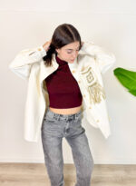 Aggiungi un tocco unico e di carattere al tuo guardaroba invernale con questa giacca oversize in velluto a costine. Realizzata in un luminoso ed elegante colore panna/bianco, unisce il calore del velluto a un design scenografico e di tendenza. Il vero punto di forza è il retro, impreziosito da dettagli intrecciati e lunghe frange sulla schiena in stile boho-chic. Fit & Design: Vestibilità oversize e rilassata, ideale per creare outfit a strati sopra maglioni pesanti durante la stagione fredda. Dettagli Glamour: Dettaglio posteriore effetto macramè/uncinetto con frange pendenti che donano movimento a ogni passo. Materiale: morbido e avvolgente velluto a costine, perfetto per proteggerti dal freddo invernale con stile. Come Abbinarla: Splendida sopra un denim grigio o nero, stivaletti o anfibi per un perfetto look street-style western e ricercato