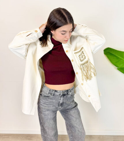 Aggiungi un tocco unico e di carattere al tuo guardaroba invernale con questa giacca oversize in velluto a costine. Realizzata in un luminoso ed elegante colore panna/bianco, unisce il calore del velluto a un design scenografico e di tendenza. Il vero punto di forza è il retro, impreziosito da dettagli intrecciati e lunghe frange sulla schiena in stile boho-chic. Fit & Design: Vestibilità oversize e rilassata, ideale per creare outfit a strati sopra maglioni pesanti durante la stagione fredda. Dettagli Glamour: Dettaglio posteriore effetto macramè/uncinetto con frange pendenti che donano movimento a ogni passo. Materiale: morbido e avvolgente velluto a costine, perfetto per proteggerti dal freddo invernale con stile. Come Abbinarla: Splendida sopra un denim grigio o nero, stivaletti o anfibi per un perfetto look street-style western e ricercato