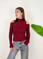 : Maglia Annabelle aderente con collo alto e maniche lunghe, impreziosita da eleganti inserti trasparenti sulle spalle. Il modello corto valorizza la silhouette ed è perfetto da abbinare a jeans o pantaloni a vita alta per un look moderno e femminile.