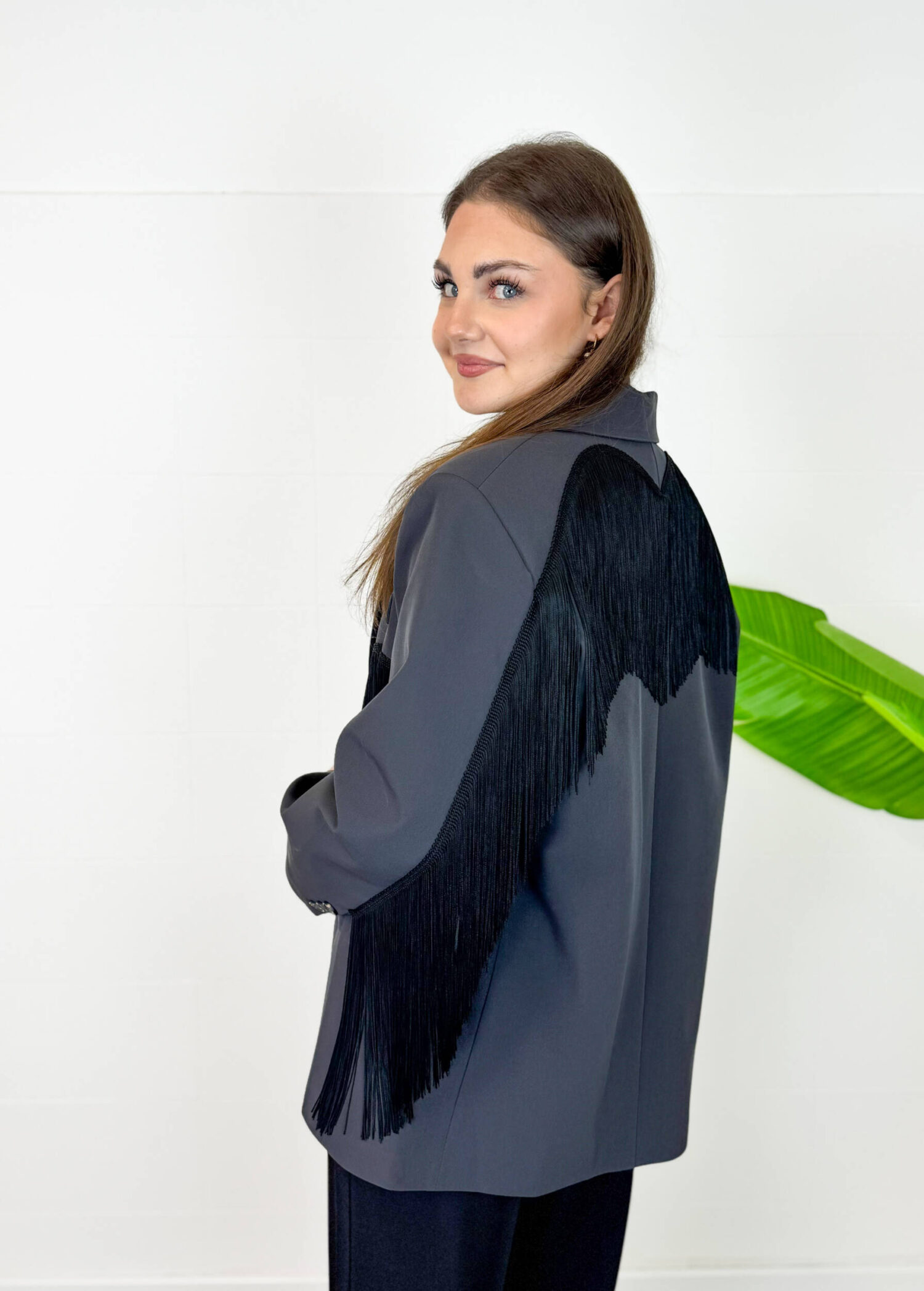 Elegante, grintoso e decisamente originale! Questo blazer da donna con frange è il capo perfetto per chi ama distinguersi con stile. Caratterizzato da un taglio leggermente oversize, presenta spalline imbottite che valorizzano la silhouette e donano struttura alla figura. Le lunghe frange decorative, presenti sia sul davanti che sul retro, creano movimento e rendono questa giacca un vero pezzo protagonista del look. Il tessuto di alta qualità, nel raffinato colore grigio nero, offre una vestibilità confortevole e un aspetto ricercato. Perfetto da abbinare a jeans e pantaloni eleganti oppure a una gonna per un outfit più sofisticato. Caratteristiche: * Blazer con frange decorative davanti e sul retro * Colore grigio nero * Vestibilità leggermente oversize * Spalline imbottite per una linea strutturata * Chiusura frontale con gancetto * Internamente foderato * Tessuto di alta qualità * Taglia unica Vestibilità e taglie: Taglia unica con vestibilità leggermente over, ideale per creare look moderni e ricercati. Veste fino a 46 (XL). La modella è alta 180 cm. Composizione: 89% poliestere, 11% elastan.