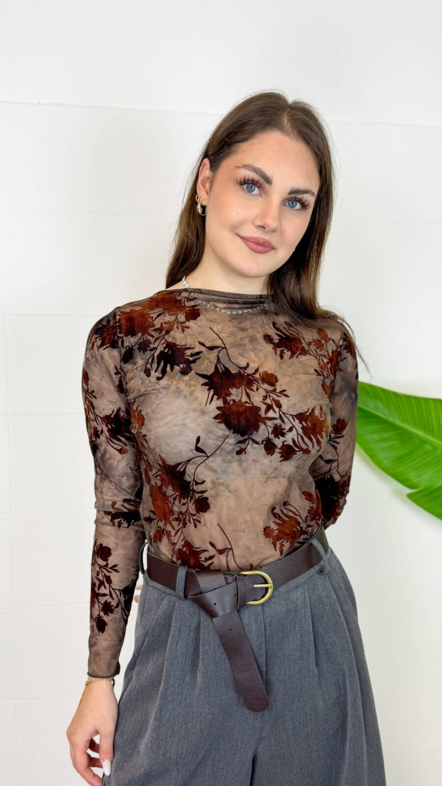 Maglia elegante in tulle trasparente con raffinato motivo floreale nei toni del marrone e del nero. Il design femminile con collo alto e maniche lunghe la rende perfetta per creare outfit sofisticati e di tendenza. Ideale da abbinare a jeans o gonne per un look chic sia di giorno che di sera.