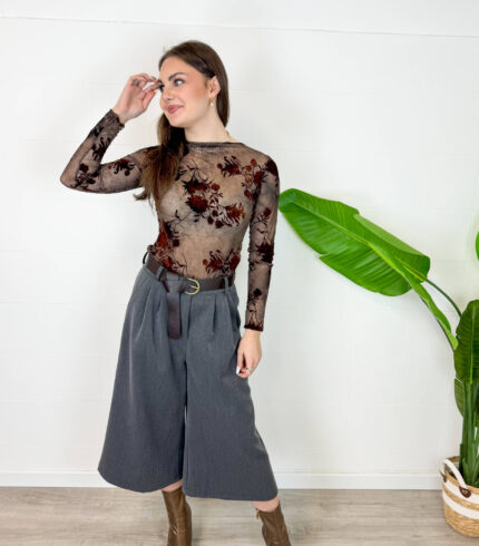 Aggiungi eleganza e modernità al tuo guardaroba con questi sofisticati pantaloni culotte colore grigio antracite/scuro. Caratterizzati da un taglio cropped a gamba molto ampia, offrono la combinazione perfetta tra la raffinatezza di una gonna e la praticità di un pantalone palazzo. Design e Dettagli: Struttura a vita alta impreziosita da eleganti pinces frontali che creano un bellissimo movimento e da una cintura coordinata in stoffa che segna e valorizza il punto vita. Vestibilità e Comfort: Gamba larga e fluida che cade morbida a metà polpaccio, garantendo massima libertà di movimento e una silhouette slanciata. Come Abbinarli: Perfetti da indossare con stivaletti o tronchetti in pelle, un body aderente o un maglioncino inserito all'interno per un look da ufficio impeccabile o un outfit serale chic ed eclettico.