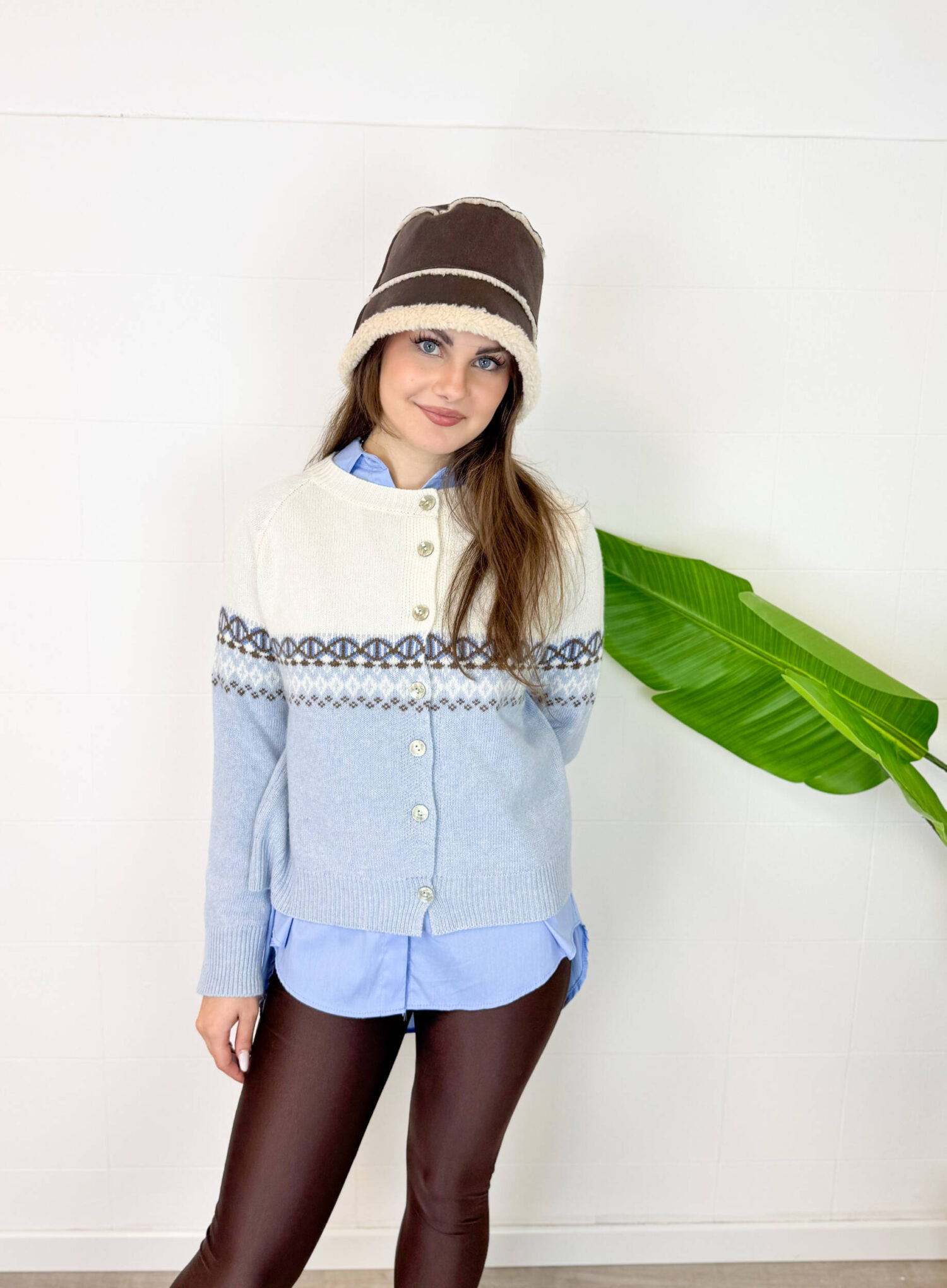Lasciati conquistare dal calore e dalla morbidezza del nostro cardigan girocollo in pregiato misto cachemire. Il design è impreziosito da una raffinata lavorazione jacquard geometrica che divide con eleganza il busto, creando un contrasto cromatico armonioso ed elegante. Dotato di una chiusura frontale con bottoni coordinati, questo maglione aperto è estremamente versatile: indossalo sopra una camicia per un look da ufficio sofisticato, oppure chiuso direttamente sulla pelle per un comfort assoluto. I bordi a coste sottili sui polsini e sull'orlo assicurano una vestibilità sempre perfetta.
