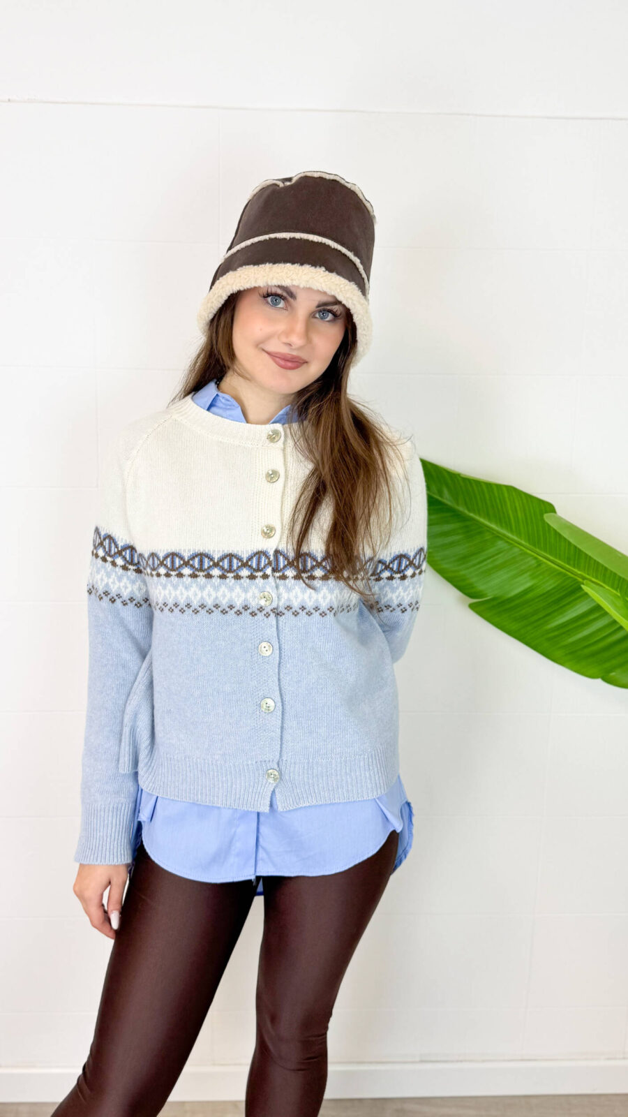 Lasciati conquistare dal calore e dalla morbidezza del nostro cardigan girocollo in pregiato misto cachemire. Il design è impreziosito da una raffinata lavorazione jacquard geometrica che divide con eleganza il busto, creando un contrasto cromatico armonioso ed elegante. Dotato di una chiusura frontale con bottoni coordinati, questo maglione aperto è estremamente versatile: indossalo sopra una camicia per un look da ufficio sofisticato, oppure chiuso direttamente sulla pelle per un comfort assoluto. I bordi a coste sottili sui polsini e sull'orlo assicurano una vestibilità sempre perfetta.